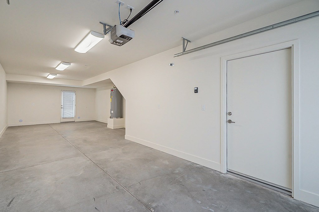 an empty room with a white door and a garage door