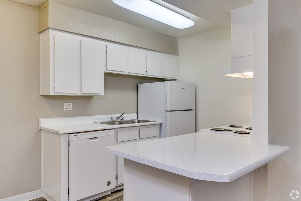 a kitchen with white cabinets and a sink and a refrigerator