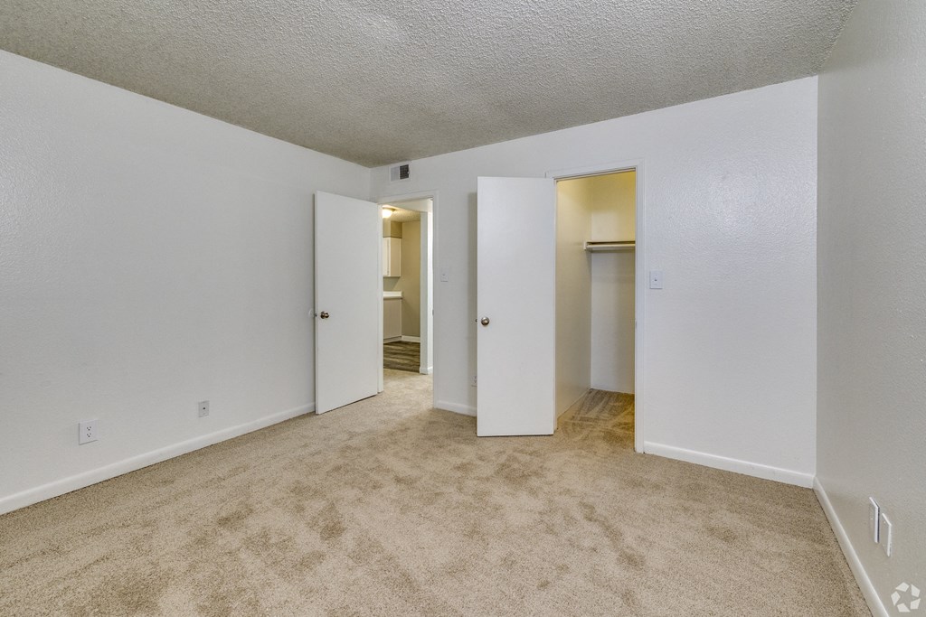 an empty living room with white walls and carpeting