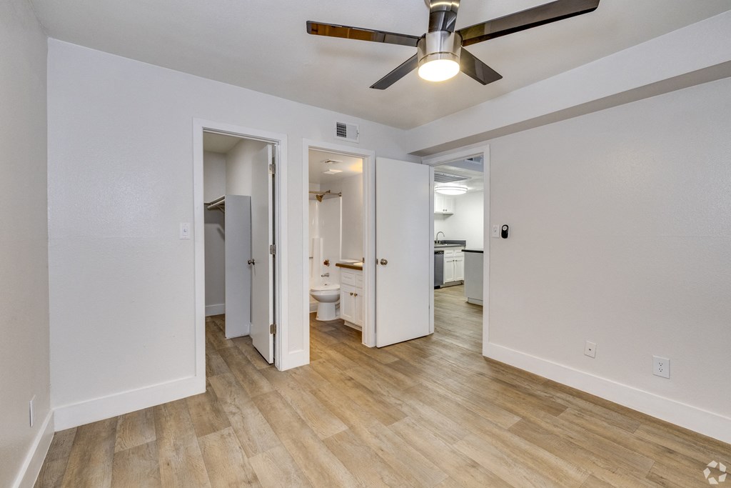 a living room with white walls and a ceiling fan