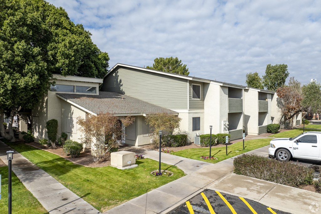 an apartment building with a white truck parked in front of it