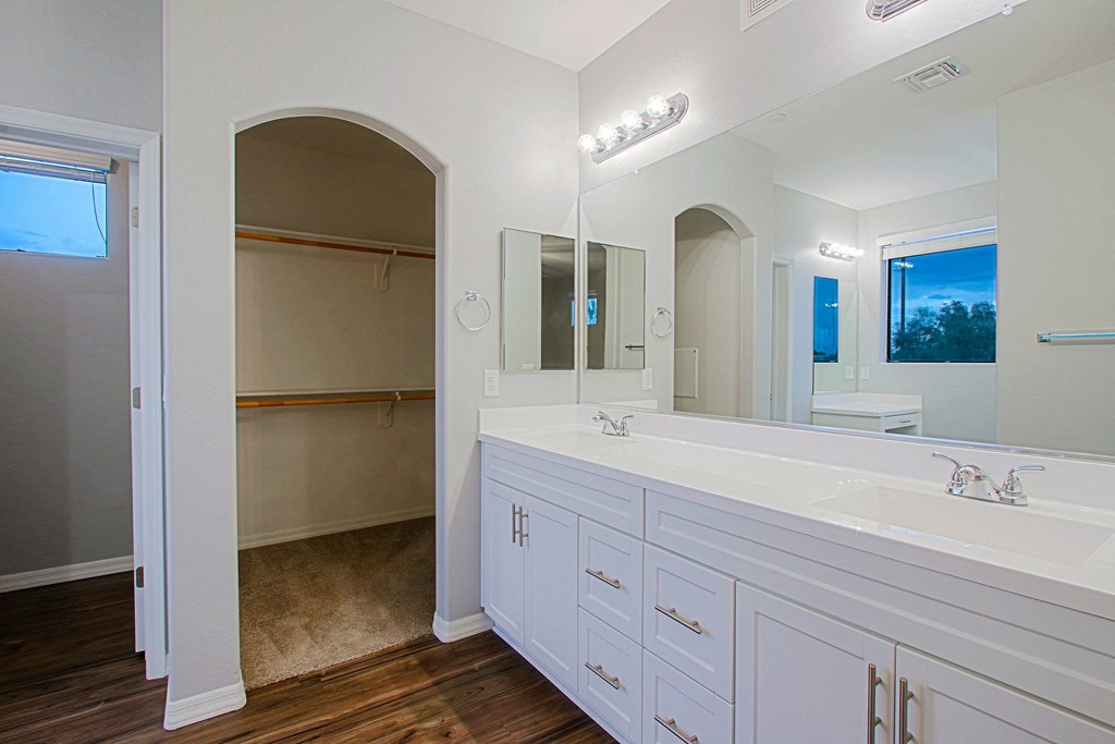 a large white bathroom with two sinks and a mirror