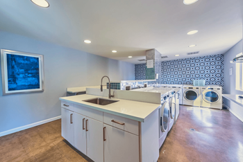 Resident On Site Laundry Room with Blue Tiled Accent Wall at The Viridian Apartments in Scottsdale, Arizona 85250