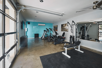Gym with exercise equipment and a large retractable door at The Viridian Apartments in Arizona 85250