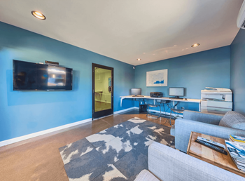 Resident Media Room with a Television and Desktop Computers at The Viridian Apartments in Scottsdale