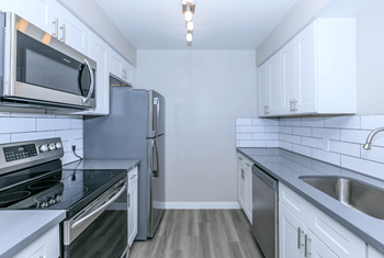 Kitchen with stainless steel appliances and white cabinets at Tides at Mesa, Mesa, Arizona