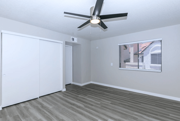 Large bedroom with plank flooring, oversized window, and ceiling fan at Tides at Mesa, Mesa