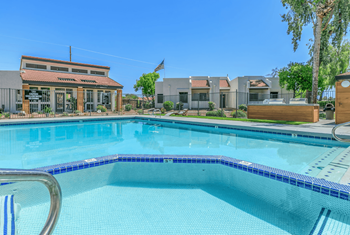 Large swimming pool with soothing spa outlined in dark blue tile at Tides on Southern in Mesa, Arizona
