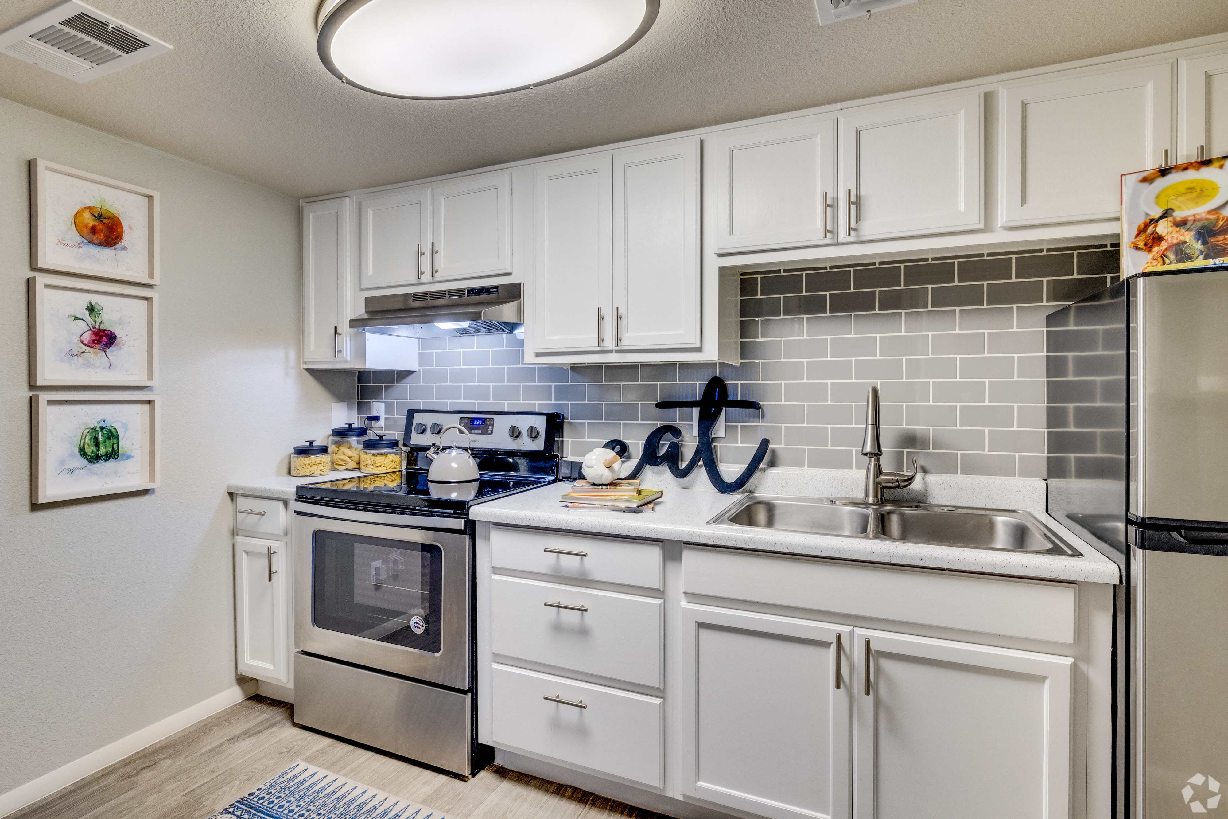a kitchen with white cabinets and stainless steel appliances and a sink