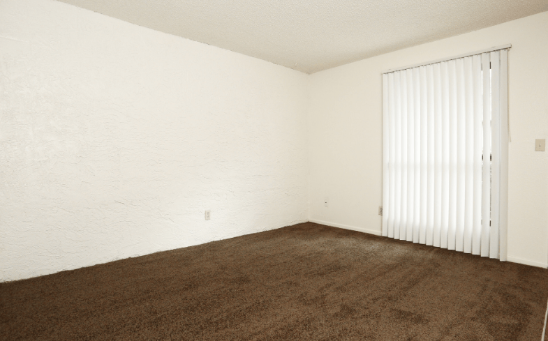 an empty room with a carpet and a large white door