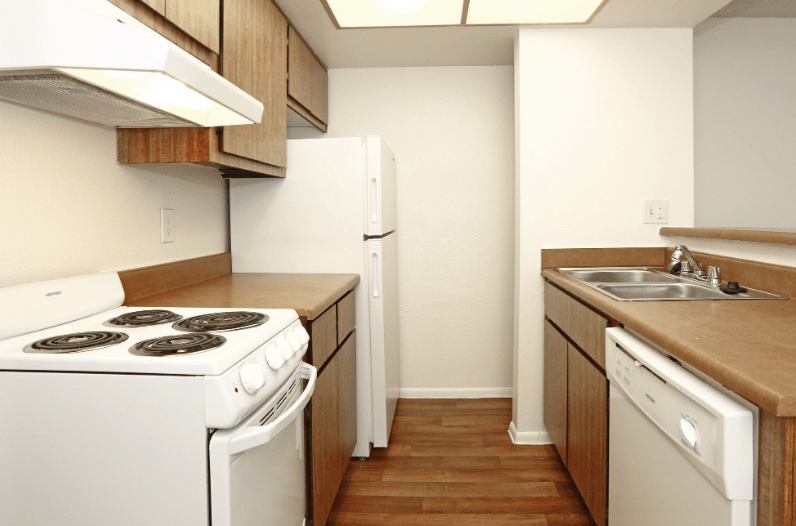 an empty kitchen with a stove refrigerator and sink