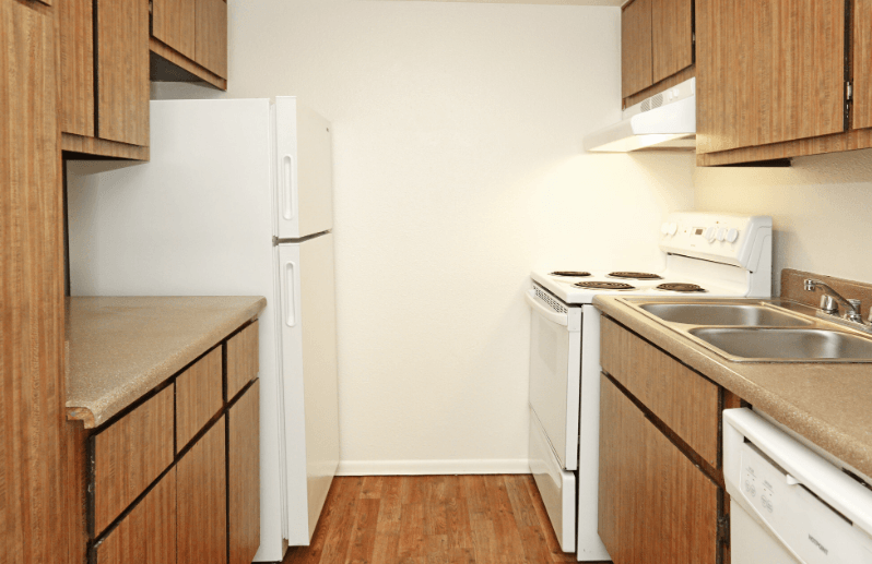 a kitchen with white appliances and wooden cabinets