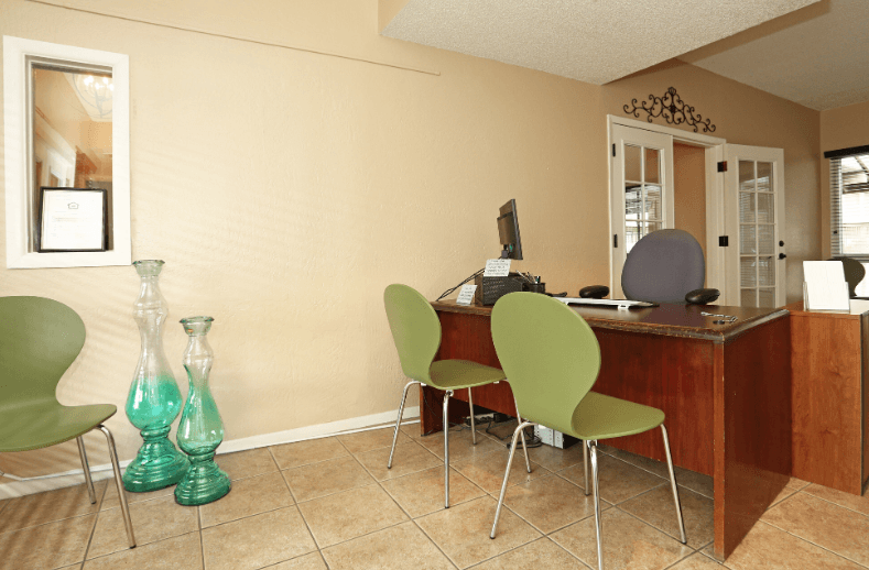 an office with green chairs and a desk with a computer