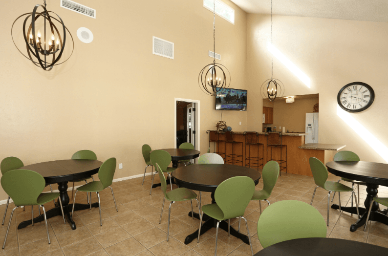 a dining room with tables and chairs and a clock on the wall