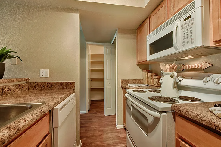 A kitchen with a stove, microwave, and oven. at Sycamore Square Apartments, Mesa, Arizona