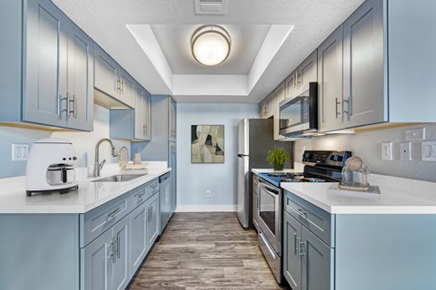 A kitchen with a white counter top and a sink.