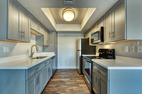 A kitchen with a refrigerator, stove, and sink.