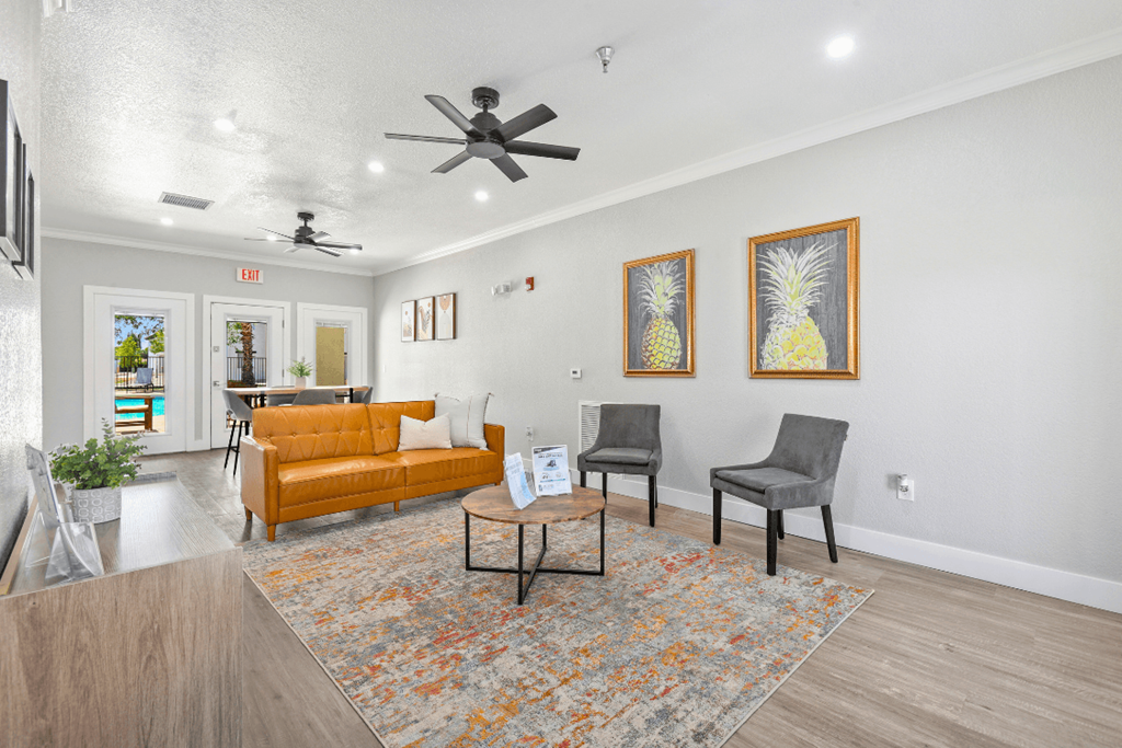 A living room with a yellow couch, two chairs, and a coffee table.