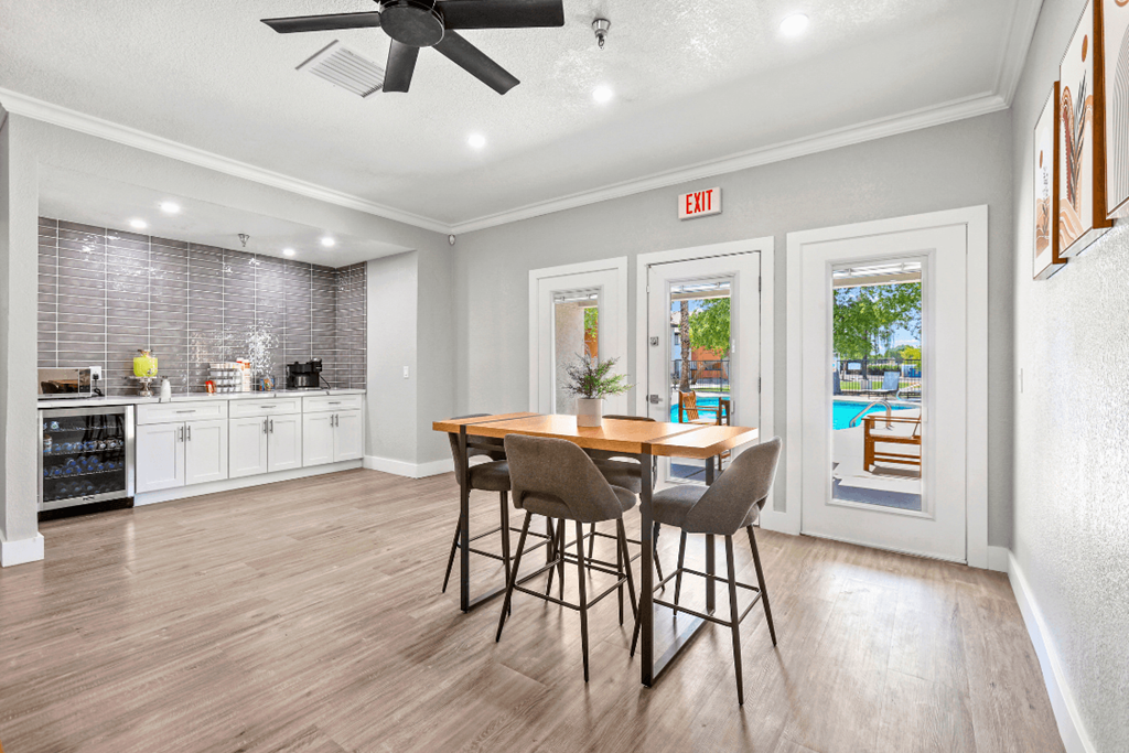 A kitchen with a dining table and chairs in the middle of the room.