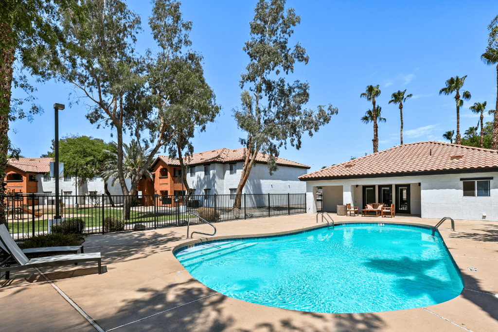 A swimming pool surrounded by trees and a fence.