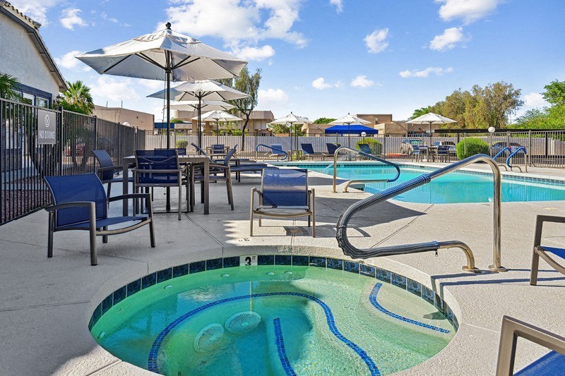 a swimming pool with chairs and umbrellas at the resort