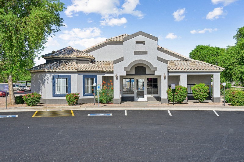 the front of a building with a parking lot
