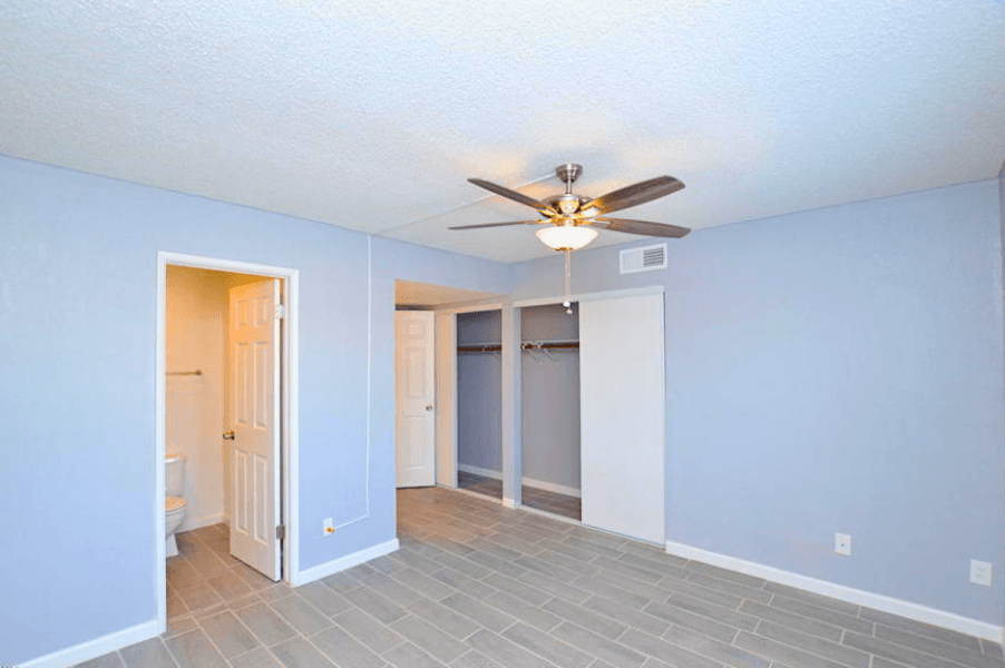 a bedroom with blue walls and a ceiling fan