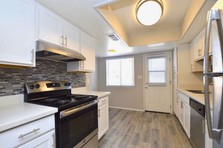 a kitchen with white cabinets and a black stove top oven