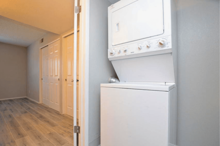 a white washer and dryer in a room with a wooden floor