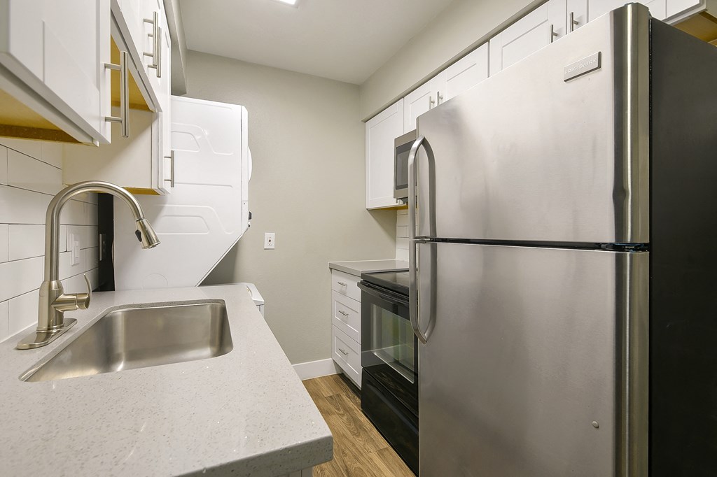a kitchen with a stainless steel refrigerator and sink