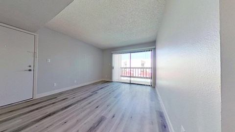 A room with a white door and a window with a view of a building outside.