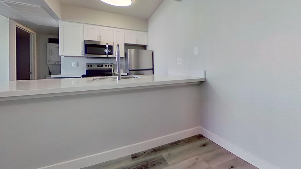 A kitchen with white cabinets and appliances.