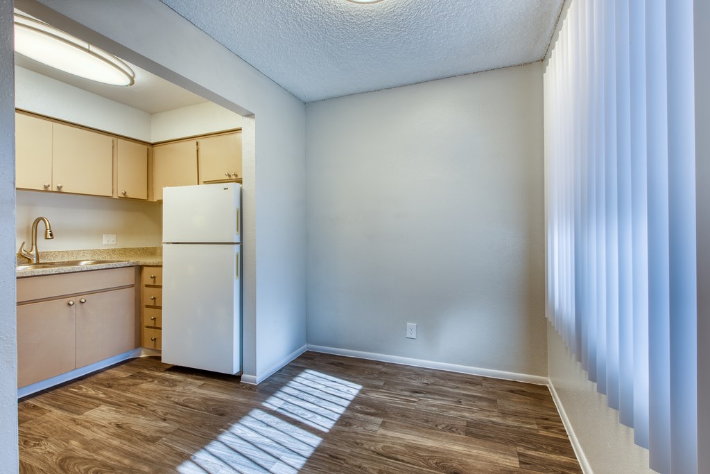 A kitchen with a white refrigerator and wooden cabinets.