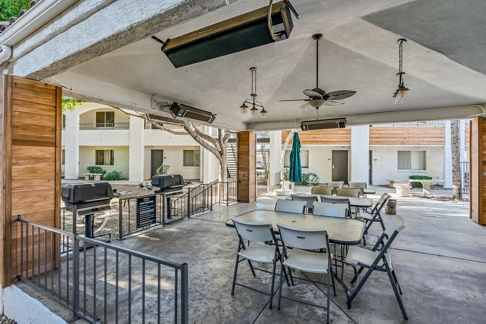 A patio with a table and chairs is covered by a roof at Tides on East Cactus Apartments, Phoenix, AZ, 85032