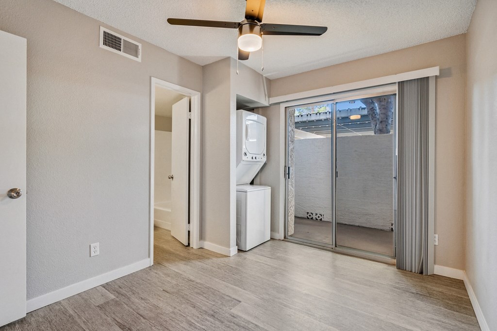 A room with a ceiling fan and a window with a view of the outside at Tides on East Cactus Apartments, Phoenix