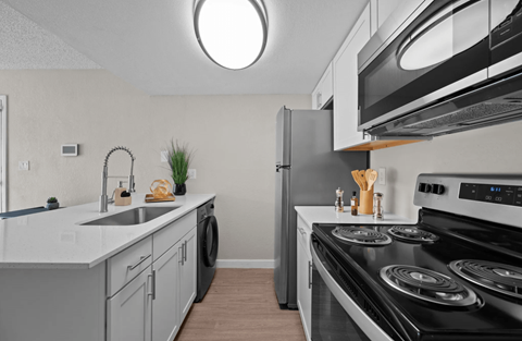 A modern kitchen with a black stove top oven and a white countertop.