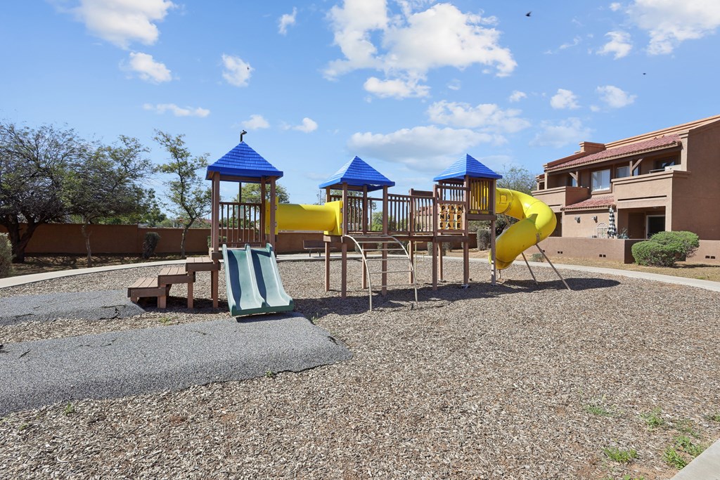a playground with slides and swings at an apartment complex