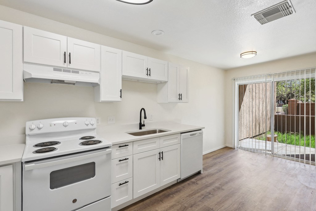 the preserve at ballantyne commons apartment kitchen with stove and sink and white cabinets