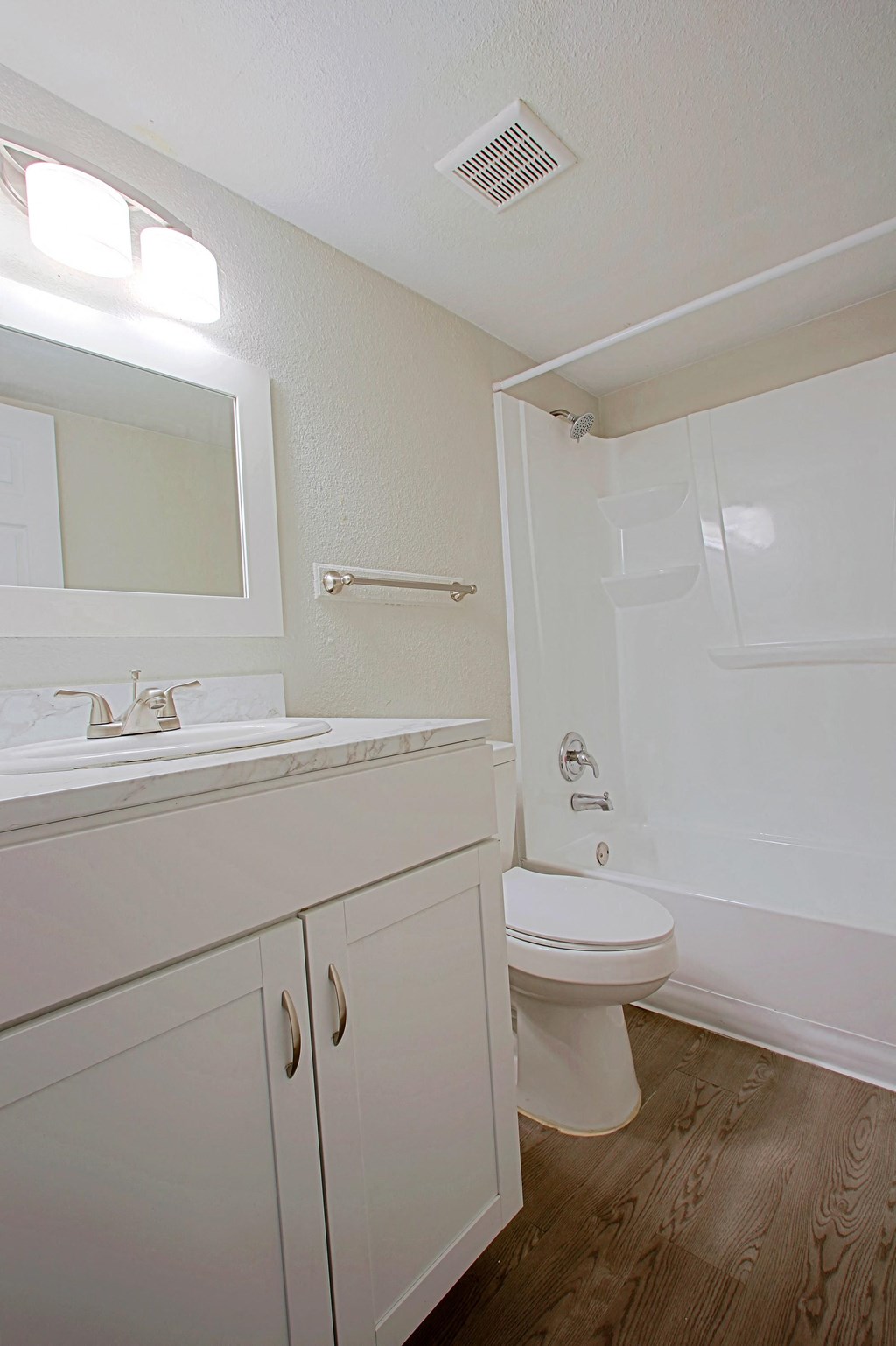 a bathroom with a toilet sink and shower and a mirror