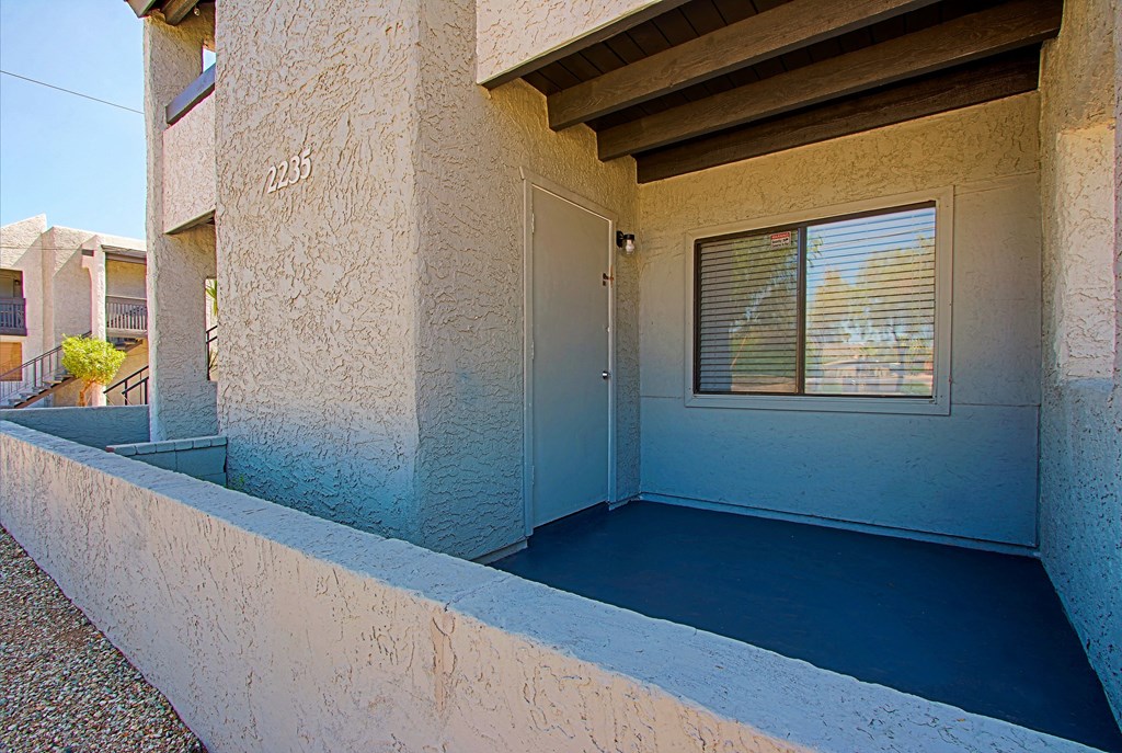 a porch of a building with a door and a window