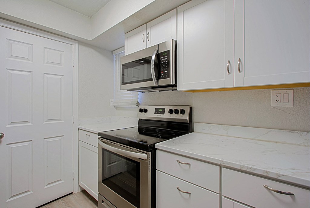 a kitchen with stainless steel appliances and white cabinets