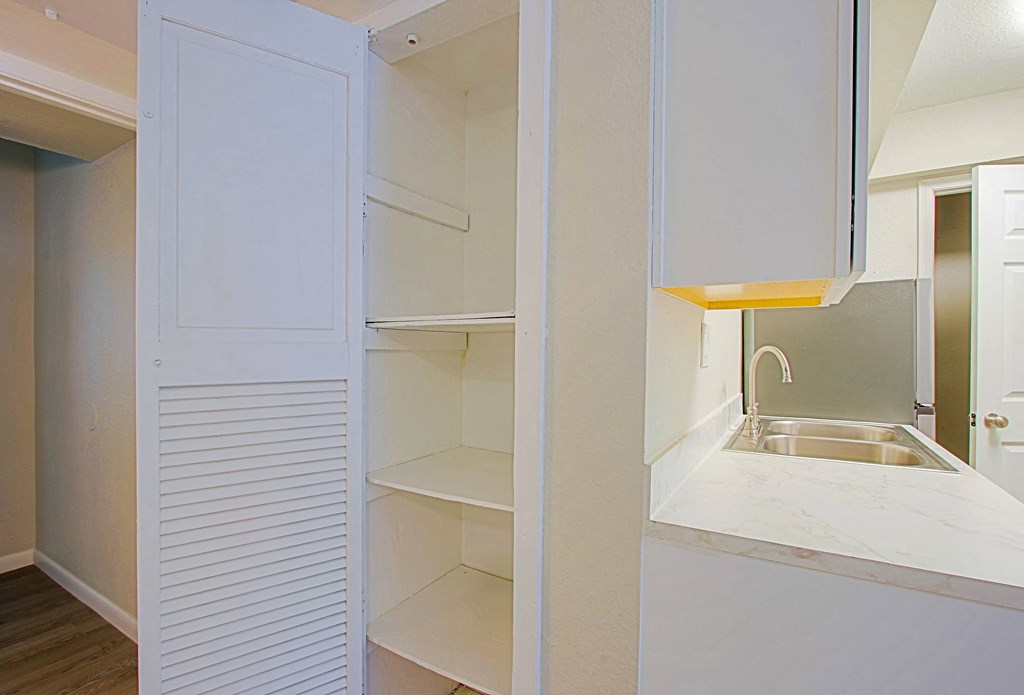 a small kitchen with white cabinets and a sink