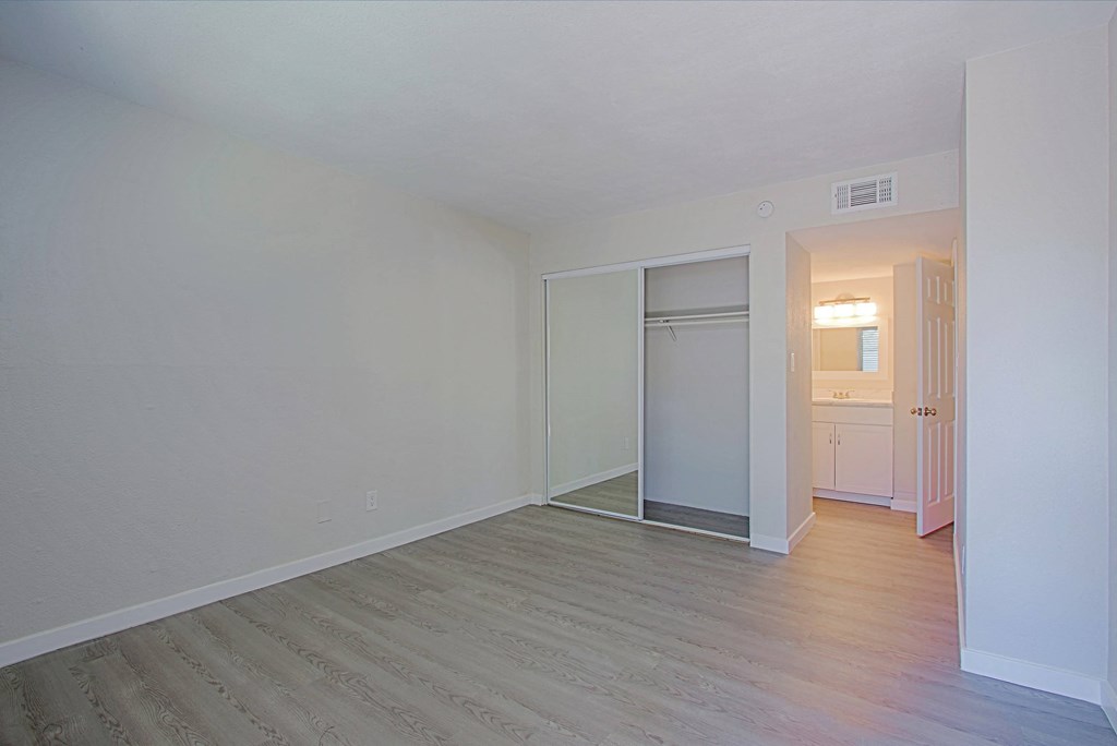 an empty living room with wood flooring and white walls