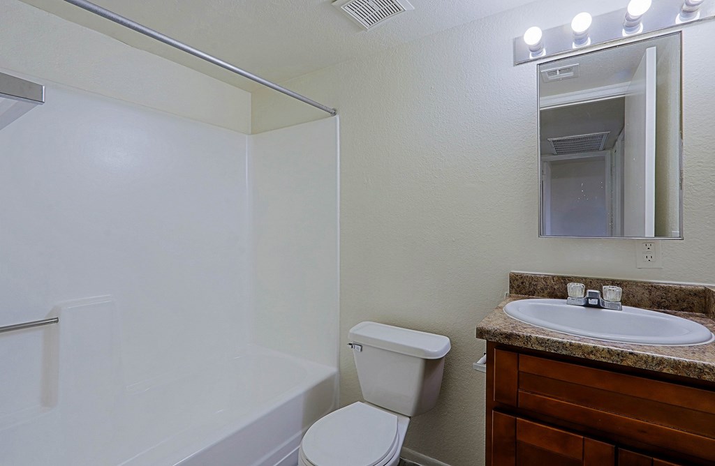 A white toilet sits next to a sink in a bathroom.
