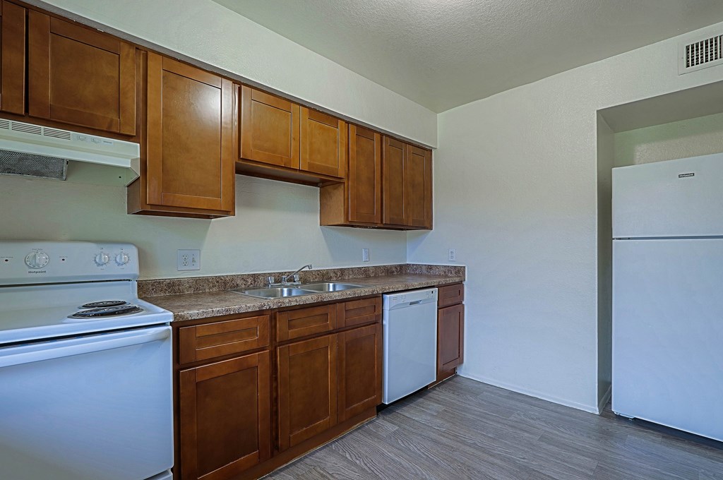 A kitchen with a white stove and a white dishwasher.