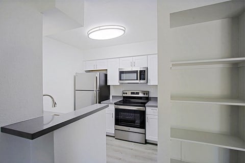 a kitchen with white cabinets and stainless steel appliances