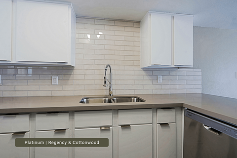 A kitchen with white cabinets and a sink.