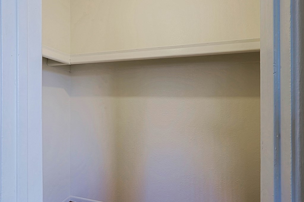 A white wall with a white cabinet above it.