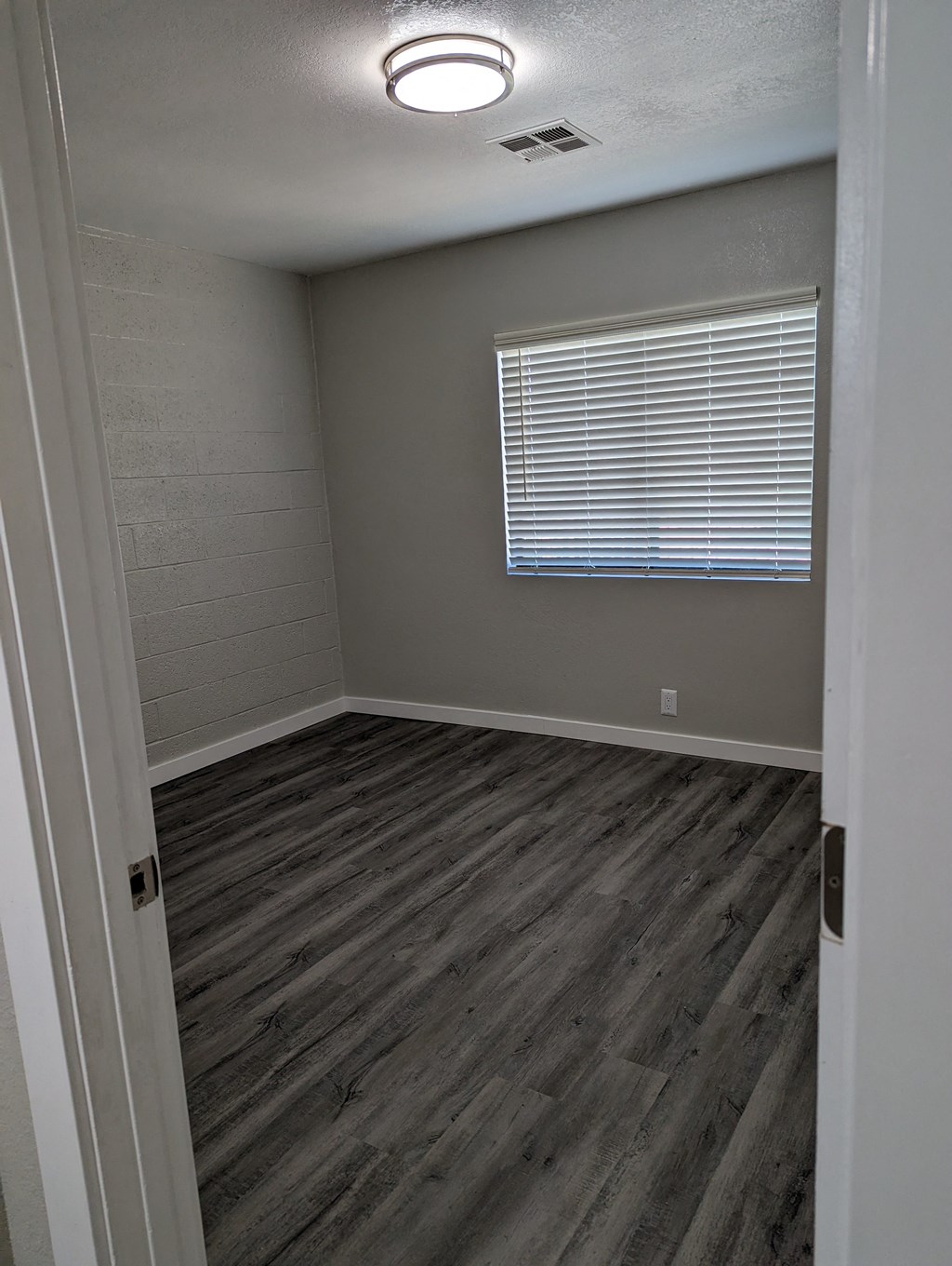 an empty room with wooden floors and a window
