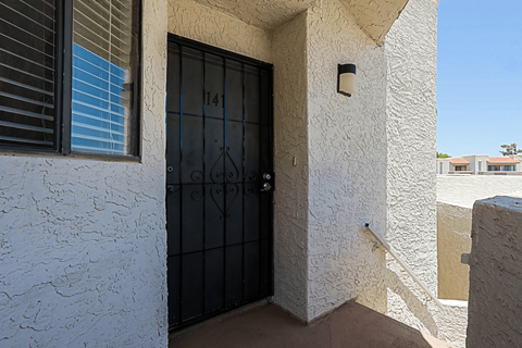A black door with the number 141 on it is on a white wall.
